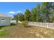 Spacious backyard featuring a well-kept lawn, a charming white picket fence, and mature trees at 16302 Vine Cliff Ave, Hudson, FL 34667