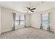 Bright bedroom with large windows, plush carpeting, and contemporary ceiling fan at 16302 Vine Cliff Ave, Hudson, FL 34667