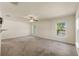 Spacious living room with ceiling fan, large windows, and neutral carpet offers lots of natural light at 16302 Vine Cliff Ave, Hudson, FL 34667