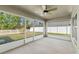 Screened patio with a ceiling fan looking out over a backyard with a white picket fence at 16302 Vine Cliff Ave, Hudson, FL 34667