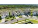 Aerial view of a residential home with a well-maintained lawn, landscaping, and surrounding neighborhood at 16934 Oval Rum Dr, Wimauma, FL 33598