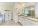 Bathroom with double sinks, granite countertops, and a built-in linen closet at 16934 Oval Rum Dr, Wimauma, FL 33598