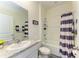 Clean bathroom featuring a shower-tub combo, modern vanity, and striped shower curtain at 16934 Oval Rum Dr, Wimauma, FL 33598