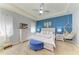 Stylish bedroom with white furniture, a ceiling fan, a hammock, and a blue accent wall at 16934 Oval Rum Dr, Wimauma, FL 33598