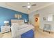 Stylish bedroom with white furniture, a ceiling fan, a hammock, and a blue accent wall at 16934 Oval Rum Dr, Wimauma, FL 33598