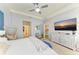 Spacious bedroom with a ceiling fan, dresser with a TV, and view to connected rooms at 16934 Oval Rum Dr, Wimauma, FL 33598