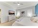 Bright bedroom with white furniture, a ceiling fan, curtains, and a view to connected rooms at 16934 Oval Rum Dr, Wimauma, FL 33598