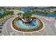 An aerial shot showcases a landscaped roundabout with a water feature at the community entrance at 16934 Oval Rum Dr, Wimauma, FL 33598