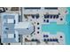 Aerial view of a community pool and lounge area, surrounded by palm trees and seating under blue umbrellas at 16934 Oval Rum Dr, Wimauma, FL 33598