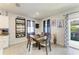 Cozy dining room with wood table, wine rack, and blue-patterned curtains at 16934 Oval Rum Dr, Wimauma, FL 33598