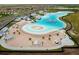 A scenic aerial view captures a vibrant community lagoon with sandy beaches and recreational water features at 16934 Oval Rum Dr, Wimauma, FL 33598