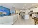 Spacious living area with blue accent wall, open kitchen, and tile flooring at 16934 Oval Rum Dr, Wimauma, FL 33598
