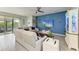 Bright living room with sliding glass doors, ceiling fan, and blue accent wall with decor and modern furniture at 16934 Oval Rum Dr, Wimauma, FL 33598