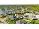 Overhead shot showcasing the home, nearby solar panels, and a community pond amidst lush greenery at 18734 Burndall Ct, Land O Lakes, FL 34638