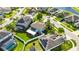 An aerial view showcases a well-maintained home with lush landscaping, a screened lanai, and a white fenced backyard at 18734 Burndall Ct, Land O Lakes, FL 34638