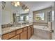 Bathroom with a large mirror, granite countertop, and a separate tub and shower at 18734 Burndall Ct, Land O Lakes, FL 34638