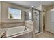 Bright bathroom features a soaking tub, separate shower, and tiled accents at 18734 Burndall Ct, Land O Lakes, FL 34638