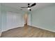 Bedroom with light green walls, wood flooring, closet, and ceiling fan with overhead lighting at 18734 Burndall Ct, Land O Lakes, FL 34638