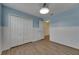 The bedroom has light blue walls, a closet, light-colored floors, and a ceiling light at 18734 Burndall Ct, Land O Lakes, FL 34638