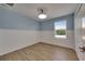Bedroom with blue accent wall, ceiling fan, and wood-look floors at 18734 Burndall Ct, Land O Lakes, FL 34638
