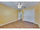 Bright bedroom featuring wood floors, double closet, and ceiling fan at 18734 Burndall Ct, Land O Lakes, FL 34638