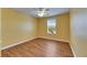 Bedroom with Yellow walls and light wood flooring with window for natural light at 18734 Burndall Ct, Land O Lakes, FL 34638