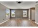 Bedroom with a neutral wall color, two windows, and wood flooring at 18734 Burndall Ct, Land O Lakes, FL 34638