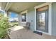 Inviting covered front porch features neutral toned brick flooring and a chair for relaxing at 18734 Burndall Ct, Land O Lakes, FL 34638