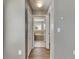 Hallway view leading to a bright bathroom with a soaking tub and a window at 18734 Burndall Ct, Land O Lakes, FL 34638