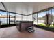 Enclosed patio featuring a hot tub with privacy screens and views of the lush backyard at 18734 Burndall Ct, Land O Lakes, FL 34638