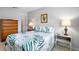 A bright bedroom with tropical-themed bedding, wooden furniture, and carpet flooring at 1901 Canterbury Ln # 14, Sun City Center, FL 33573