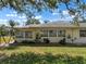 This home features lush landscaping, with a well-maintained lawn, healthy shrubs, and a backdrop of mature trees at 1901 Canterbury Ln # 14, Sun City Center, FL 33573