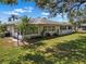 This home features lush landscaping, with a well-maintained lawn, healthy shrubs, and a backdrop of mature trees at 1901 Canterbury Ln # 14, Sun City Center, FL 33573