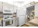Bright kitchen features white appliances, ample cabinet space, and an adjacent dining area at 1901 Canterbury Ln # 14, Sun City Center, FL 33573