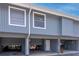 This gray condo features two stories, covered parking, and a welcoming front door with beautiful landscaping at 200 Meres Blvd # 7, Tarpon Springs, FL 34689