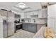 Modern kitchen with stainless steel appliances, grey cabinets, and patterned tile floors at 200 Meres Blvd # 7, Tarpon Springs, FL 34689