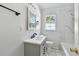 Updated bathroom features white marble tiled shower, modern vanity, black hardware, and natural light at 2001 Spooner Dr, Plant City, FL 33563