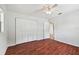 Bedroom with hardwood floors and bright closet with white bi-fold doors at 2001 Spooner Dr, Plant City, FL 33563