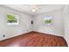 Bright bedroom features hardwood floors, two windows, a ceiling fan and ample space at 2001 Spooner Dr, Plant City, FL 33563