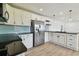 Well-lit kitchen with white cabinets, stainless steel appliances, black countertops, and updated fixtures at 2001 Spooner Dr, Plant City, FL 33563