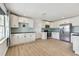 Bright kitchen features white cabinets, stainless steel appliances, light blue backsplash, and wood-look floors at 2001 Spooner Dr, Plant City, FL 33563