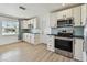 Updated kitchen with white cabinets, stainless steel appliances, black countertops, and light wood-look flooring at 2001 Spooner Dr, Plant City, FL 33563