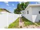 Narrow side yard with a white fence and brick walkway at 2001 Spooner Dr, Plant City, FL 33563