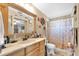 Nautical-themed bathroom featuring a wooden vanity, shower with curtain, and decorative wall decor at 2087 59Th N St, Clearwater, FL 33760