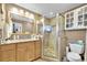 Bright bathroom featuring a glass-enclosed shower, granite vanity, and ample storage space at 2087 59Th N St, Clearwater, FL 33760