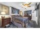 Comfortable bedroom featuring a decorative ceiling fan, dark wood furniture, and patterned bedding at 2087 59Th N St, Clearwater, FL 33760