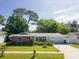 Charming single-story home featuring colorful exterior, lush landscaping, and a two-car garage at 2087 59Th N St, Clearwater, FL 33760