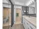 Bright bathroom features a white vanity, a framed mirror, and access to the walk in shower at 2700 Bayshore Blvd # 9209, Dunedin, FL 34698