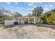 Exterior view of a single-story home with a covered parking and spacious gravel area at 2819 N 75 St, Tampa, FL 33619