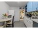 Galley kitchen with white cabinets and appliances plus eat in breakfast area with round table at 2819 N 75 St, Tampa, FL 33619